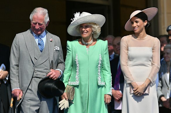 From left, Prince Charles, his wife Camilla, the Duchess of Cornwall, and Meghan, the new Duchess of Sussex attend a garden party at Buckingham Palace in London.