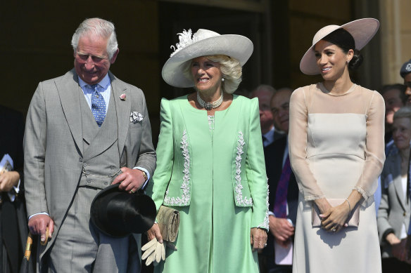 From left, Prince Charles, his wife Camilla, the Duchess of Cornwall, and Meghan, the new Duchess of Sussex attend a garden party at Buckingham Palace in London.