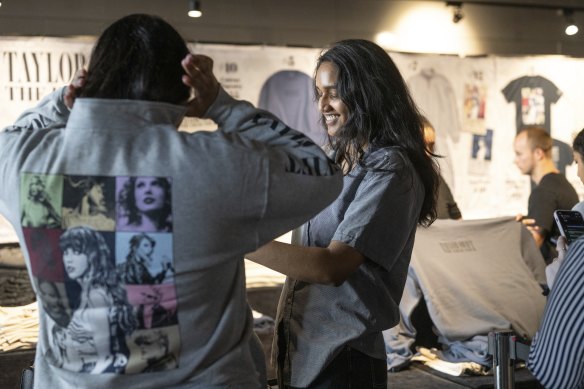 Atara Thenabadu (right) and sister Arianna try on their merch at the Crown pop-up. 