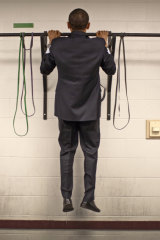 Before this photo is taken, two staffers pass the bar and do two pull-ups each. Not to be outdone, Obama does three with ease, then walks out to make a speech.