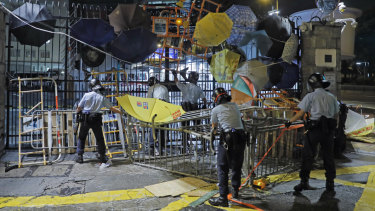 Riot police clear barricades blocked by protesters outside the police headquarters as thousands gathered to demand an independent inquiry into a heavy-handed police crackdown at a protest earlier this month.