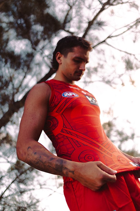 Ugle-Hagan takes a closer look at the Suns’ Sir Doug Nicholls Round guernsey designed by Larrakia artist Trent Lee.