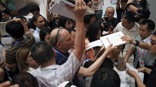 Reporters scramble to get copies of the China's national defense white paper before a press conference at the State Council Information Office in Beijing on Wednesday.