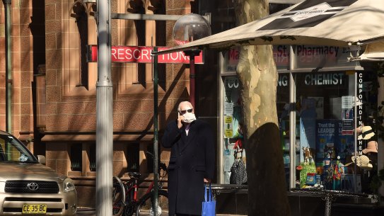A man wearing a face mask stands on Macquarie Street in Sydney, NSW. 18th August, 2020. Photo: Kate Geraghty Coronavirus
