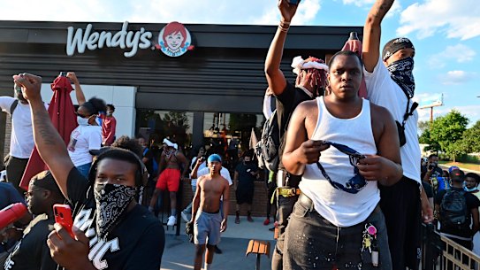 Protesters demonstrate outside a Wendy's restaurant in Atlanta, Saturday, June 13, where Rayshard Brooks, a black man, was shot and killed by Atlanta police on Friday evening following a struggle in the drive-thru line.