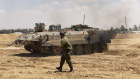 Incursion. An Israeli soldier walks near an armoured personnel carrier near the border with the southern Gaza Strip. 