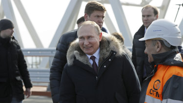 Russian President Vladimir Putin, centre, visits inspects the road section of the road-rail bridge linking Crimea to mainland Russia near Kerch, Crimea in March 2018.