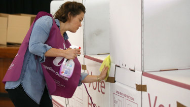 An election official sanitises a polling booth at the March council election in Brisbane.