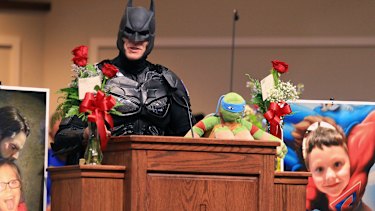 A speaker, dressed as Batman, honours six-year-old Jacob Hall.