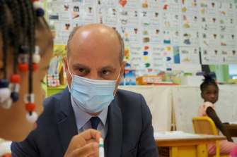 French Education Minister Jean-Michel Blanquer, seen talking with a primary school student in September 2020, said the student union Unef was racist for barring white people from discrimination meetings. 