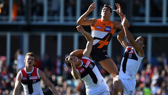 Isaac Cumming soars over a pair of Saints.