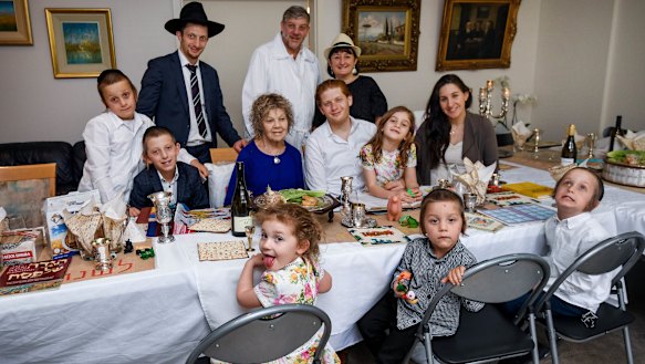 Masha Fisher surrounded by family at the table for Passover as easing health restrictions allow the Jewish gathering to occur in homes.