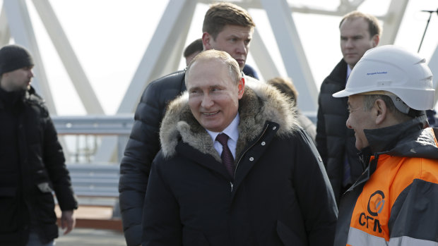Russian President Vladimir Putin, centre, visits inspects the road section of the road-rail bridge linking Crimea to mainland Russia near Kerch, Crimea in March 2018.