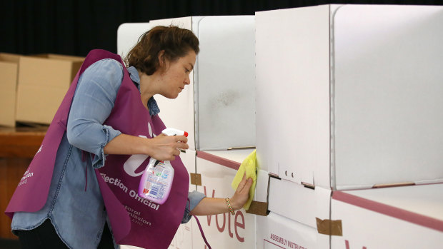 An election official sanitises a polling booth during council elections in March.