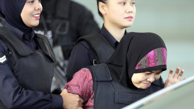 Indonesian Siti Aisyah, right, is escorted by police as she leaves court on Thursday.