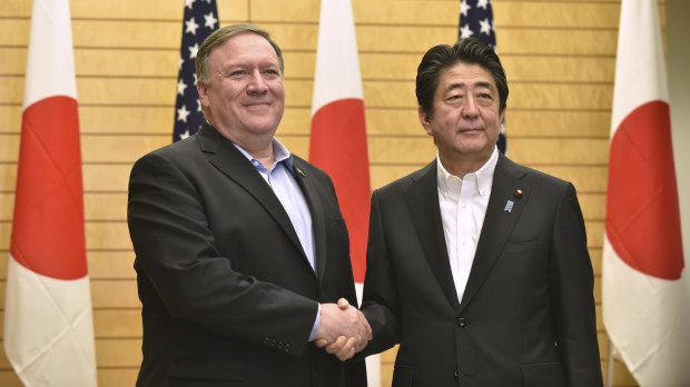 US Secretary of State Mike Pompeo, left, shakes hands with Japanese Prime Minister Shinzo Abe at the prime minister's office in Tokyo, on  Sunday.