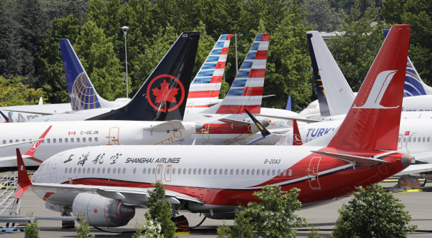 Dozens of grounded Boeing 737 MAX planes crowd a parking area in Seattle. Pilots say earlier versions of the plane, which are still in the air, may have safety risks too. 