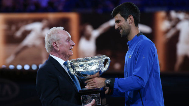 Novak Djokovic presents Laver with a trophy to mark the 50th anniversary of his second Grand Slam on January 14, 2019.