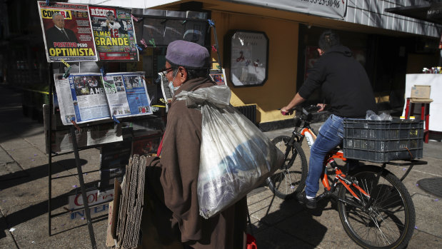 A man reads the front pages of newspapers showing the news the Mexican President Andres Manuel Lopez Obrador has COVID-19, at a kiosk on Paseo de la Reforma in Mexico City.