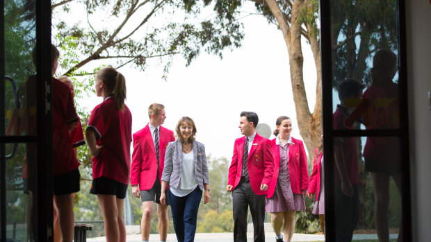 Principal Maria Karvouni strolls through the school grounds with students celebrating their VCE results