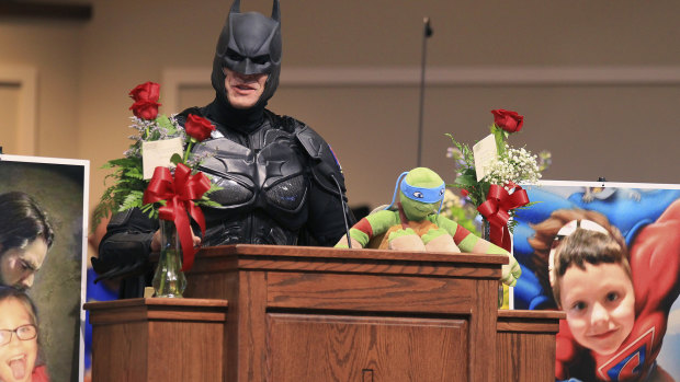 A speaker, dressed as Batman, honours six-year-old Jacob Hall.