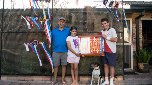 Mr Portelli with his son Eric, daughter Claire and some of his finch ribbons at his home in Sans Souci.