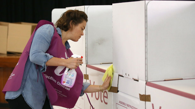 An election official sanitises a polling booth during council elections in March.