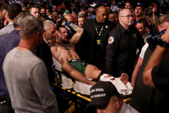 Conor McGregor is carried out of the arena after breaking his leg.