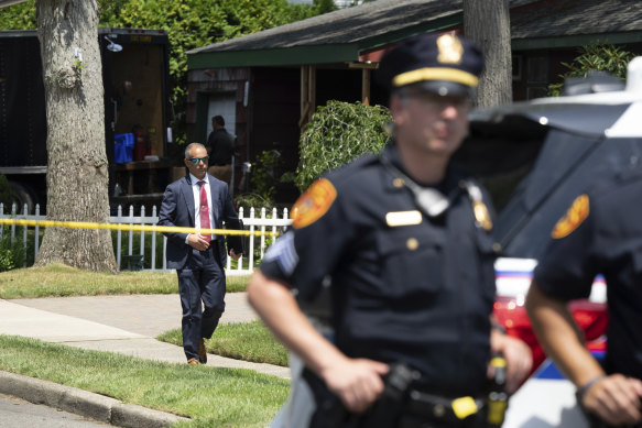 Kolluk kuvvetleri 15 Temmuz Cumartesi günü New York, Massapequa Park'ta Rex Heuermann'ın evini ararken polis memurları nöbet tutuyor.