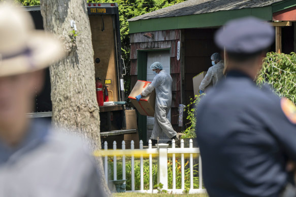 Crime laboratory officers removes boxes as law enforcement officials search the home of Rex Heuermann in Massapequa Park, New York. 