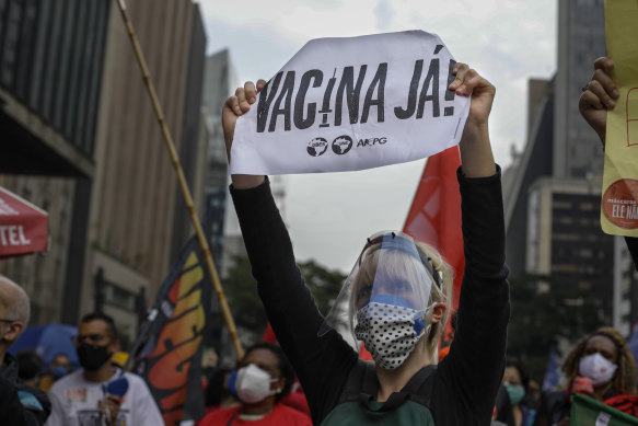 A demonstrator holds a sign that reads in Portuguese; “Vaccine now”, during a protest against Brazilian President Jair Bolsonaro.