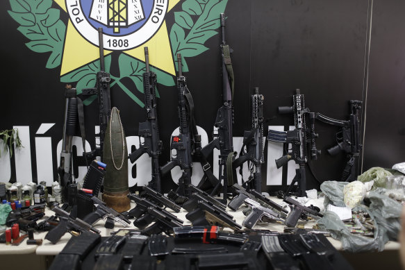 Weapons and drugs seized during a police raid are displayed for the press.