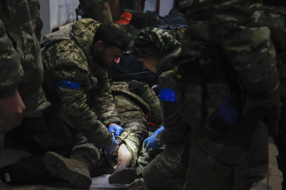 Ukrainian servicemen administer first aid to a wounded soldier in a shelter in Soledar, the site of heavy battles with Russian forces in the Donetsk region.