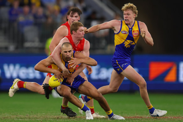 Matt Rowell of the Suns tackles Dom Sheed of the Eagles.