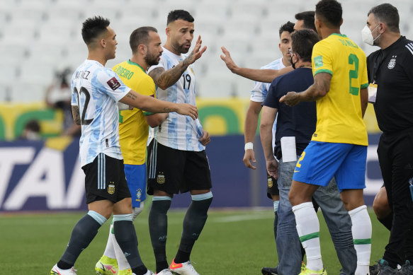 Brazil and Argentina players talk as the game is interrupted by health authorities.