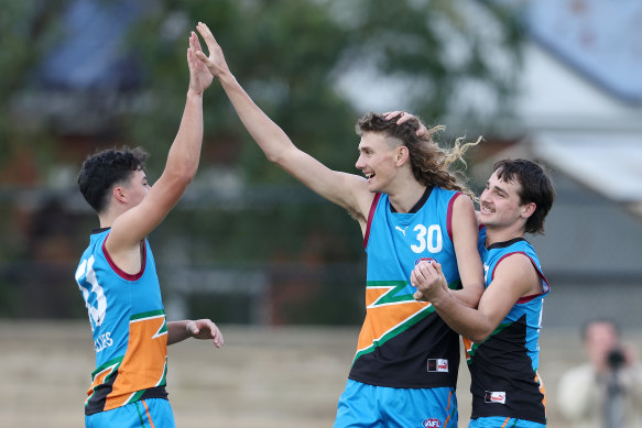 Charlie McCormack (centre) celebrates an Allies goal with Jack Callinan (left), son of former Crow Ian.