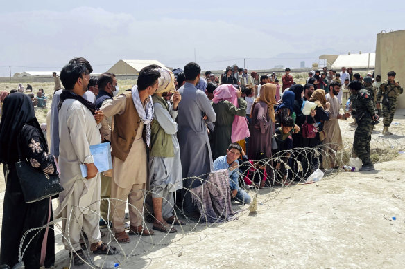 Guards try to maintain order as hundreds of people attempt to flee Afghanistan via Kabul’s international airport earlier this week.