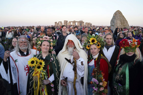 People gather during sunrise as they take part in the Summer Solstice at Stonehenge.