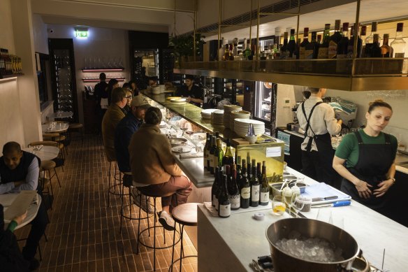 Behind the marble bench, chefs slice salumi and shuck oysters.