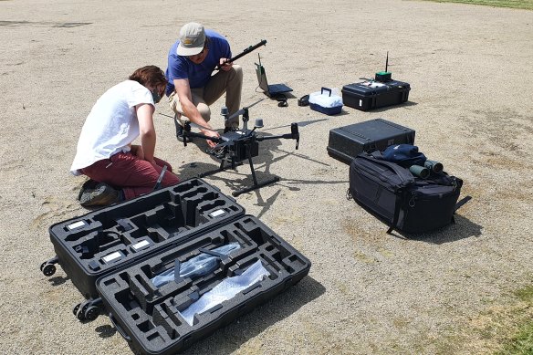 Researchers prepare a drone to locate endangered animals that are radio-tagged.