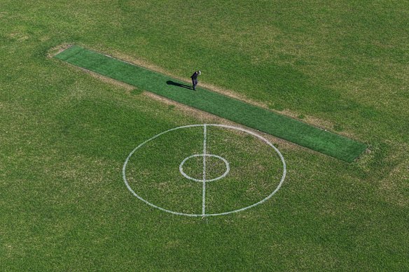 A man inspects the synthetic cricket pitch at Lalor Reserve.