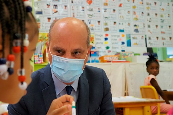 French Education Minister Jean-Michel Blanquer, seen talking with a primary school student in September 2020, said the student union Unef was racist for barring white people from discrimination meetings. 