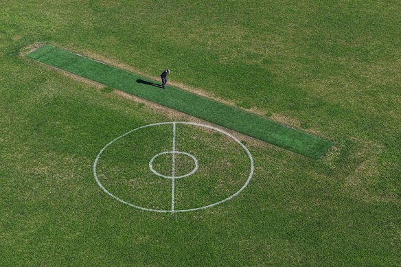 A man inspects the synthetic cricket pitch at Lalor Reserve.