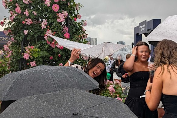Sudden downpour at Flemington catches racegoers off guard on Derby Day.