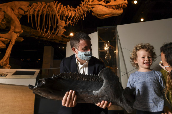Museum Victoria Palaeontologist Dr Erich Fitzgerald shows Avery Fitzgerald, 3, from Eltham, a replica of the mandible of the recently acquired near-complete adult triceratops fossil.