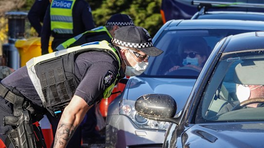 Victoria Police officers stop motorists leaving metropolitan Melbourne at a checkpoint on the border of Sunbury and Gisborne. The spike in cases in Victoria has seen Premier Daniel Andrews declare a state of disaster.
