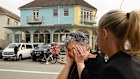 A woman reacts after placing a visitation stone near the crime scene at Bondi Beach following the mass shooting .