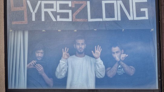 Refugees at the Park Hotel including Mehdi (left) watch the protests on the street during Djokovic’s detention. 