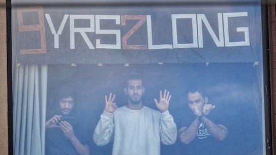 Refugees at the Park Hotel including Mehdi (left) watch the protests on the street during Djokovic’s detention. 