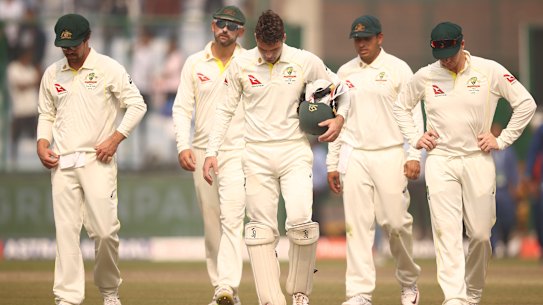 The Australians leave the field after defeat in Delhi.